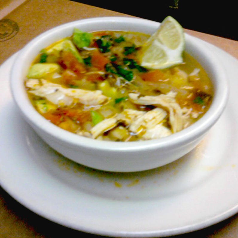 Close-up of businessmen signing documents at a wooden table in an office.